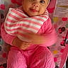 Jazmone is registered to the contest to win money with this photo: baby, child, infant, pink_clothing, headband, bib, polka_dot, baby_seat, cute, smiling, playful, hand_motion, indoor, portrait, young_child, knit_pants, white_socks, colorful_background, happy, face