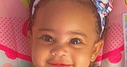 Jazmone is registered to the contest to win money with this photo: toddler, child, smiling, headband, curly_hair, cute, portrait, baby, face, pink_background, clothing, earrings, happy, indoor, colorful, pattern, closeup, person, youth, infant