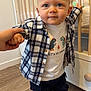 Zyan a rejoint le concours — aidez-le/la à gagner de superbes lots ! toddler, child, baby, standing, hand_holding, plaid_shirt, tshirt, dinosaur_graphic, sneakers, footwear, crib, wooden_furniture, flooring, indoors, person, cute, blue_eyes, short_hair, expression, support