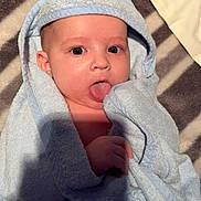 Vaelen joined the competition — help win amazing prizes! baby, child, towel, blue, hooded_towel, tongue_out, blanket, striped, cute, infant, skin, face, hand, lying_down, soft_texture, cozy, indoors, expression, playful, wrapped