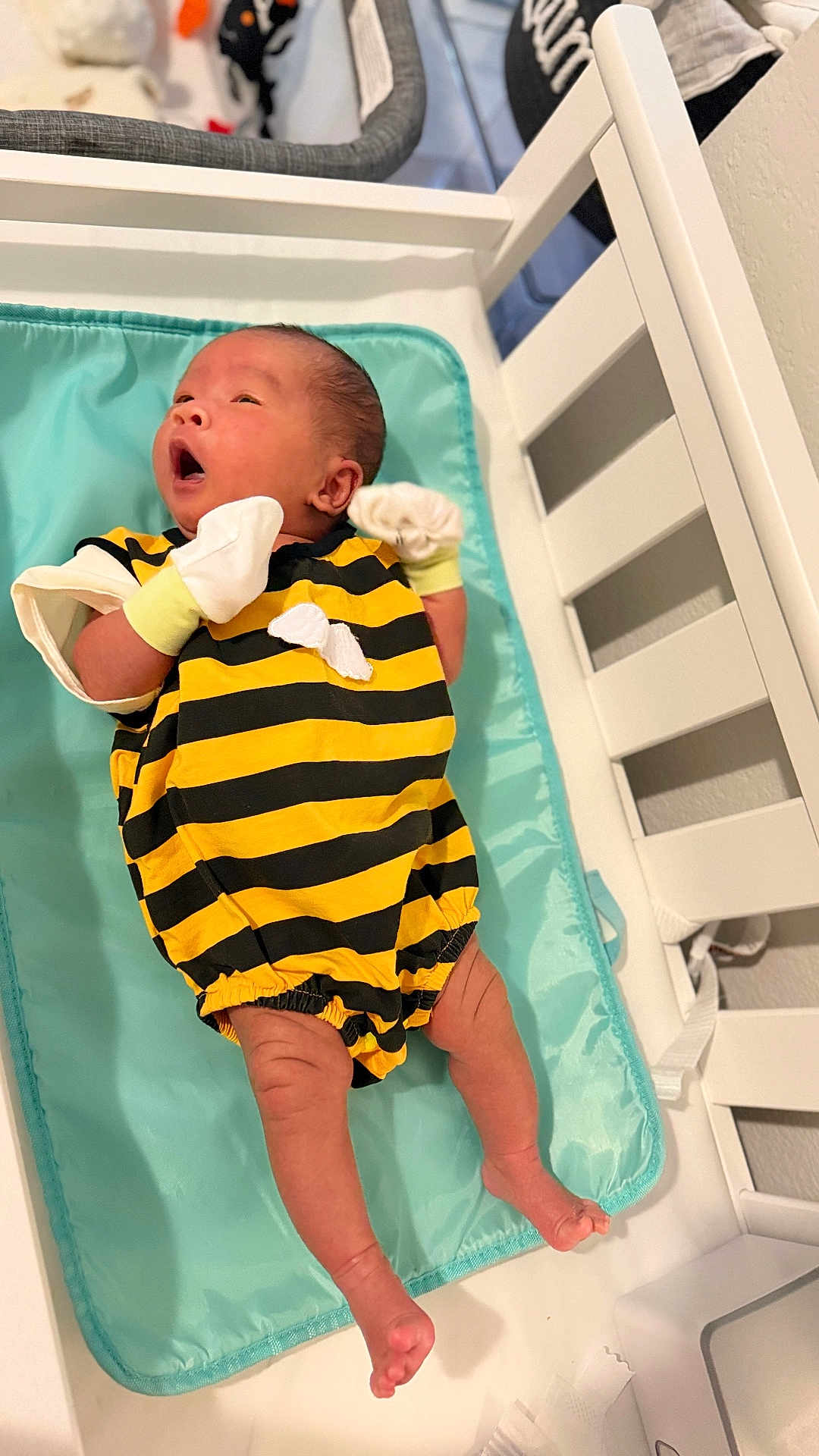 Liam joined the competition — help win amazing prizes! baby, infant, newborn, bedding, changing_pad, crib, clothing, striped_outfit, mittens, yellow, black, person, indoor, cute, small, lying_down, expression, skin, legs, feet