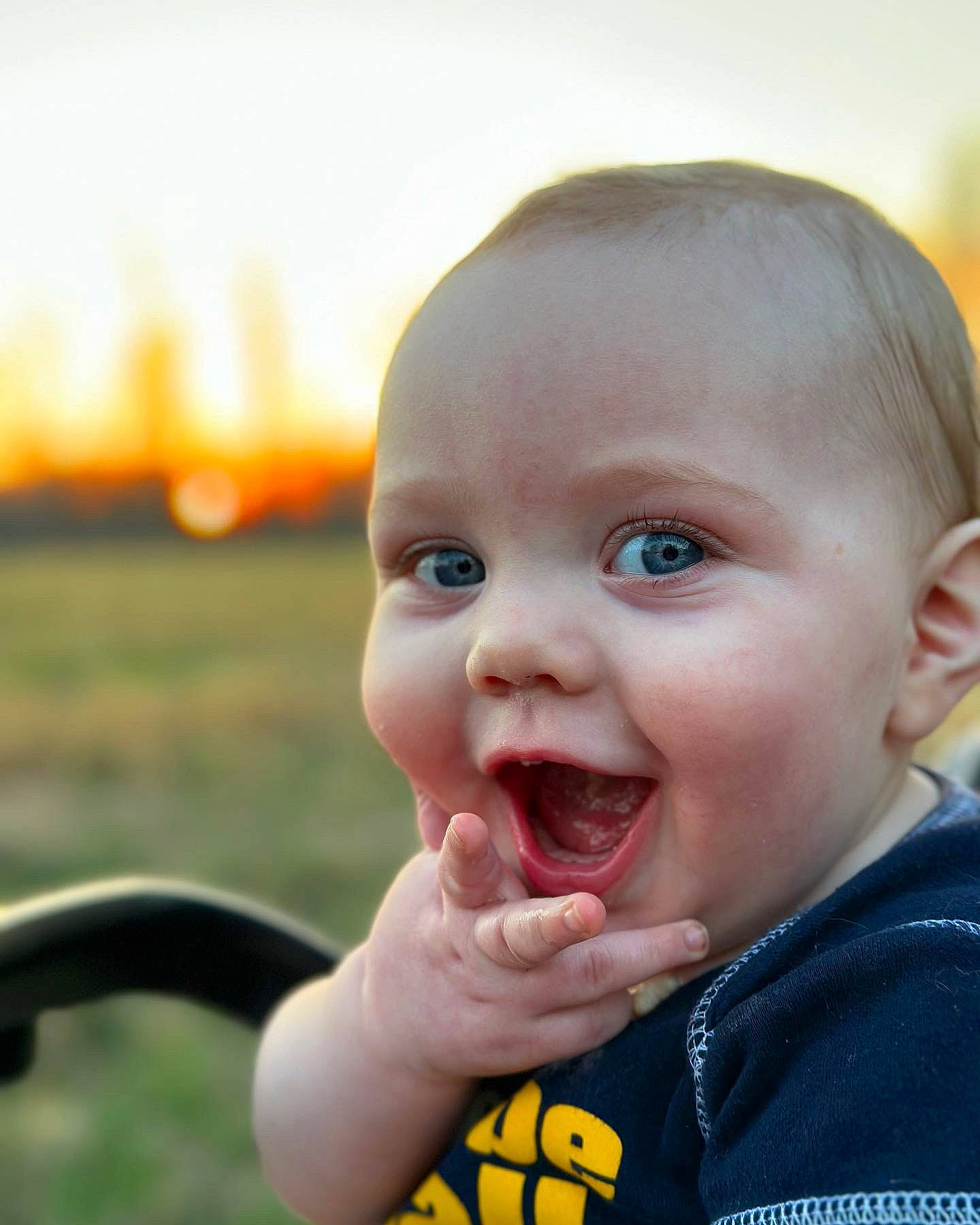 Jc is registered to the contest to win money with this photo: baby, baby_laughing, baby_toddler_clothing, cheek, chin, cool, finger, fun, gesture, grass, happy, lip, mouth, nose, person, skin, sky, smile, thumb, toddler