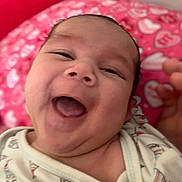 Kaizen joined the competition — help win amazing prizes! baby, infant, smiling, laughing, close_up, face, child, onesie, clothing, blanket, pink, heart_pattern, happy, cute, skin, mouth, expression, lying_down, indoors, portrait