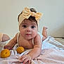 Nëyla participe au concours pour gagner de l'argent avec cette photo : baby, infant, headband, bow, blanket, fruit, apricot, child, cute, lying_down, indoors, soft_lighting, skin, face, hand, eyes, expression, white_background, clothing, toddler