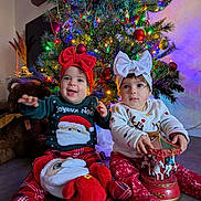 Nëyla participe au concours pour gagner de l'argent avec cette photo : toddler, christmas_tree, holiday, child, smiling, toy, plush, sweater, bow, headband, indoor, decorations, festive, floor, cute, holiday_lights, red, white, green, happy