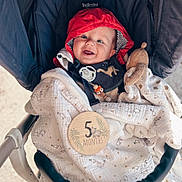 Noa a rejoint le concours — aidez-le/la à gagner de superbes lots ! baby, babylaughing, bonnet, cap, clothing, coat, face, happy, hat, head, hood, jacket, knitwear, person, photography, portrait, smile, stroller, sweater, sweatshirt