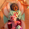baby, infant, yawning, stuffed_toy, pink_bear, cushioned_seat, soft_toys, clothing, white_top, red_pants, footprints, abc_blocks, adorable, cute, sleepy, portrait, child, indoor, comfort, baby_care