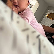 Raelynn joined the competition — help win amazing prizes! baby, infant, pink_clothing, hat, face, person, adult, hand, indoor, bedroom, blanket, cozy, home, candid, closeup, sleepwear, comfort, skin, headwear, expression