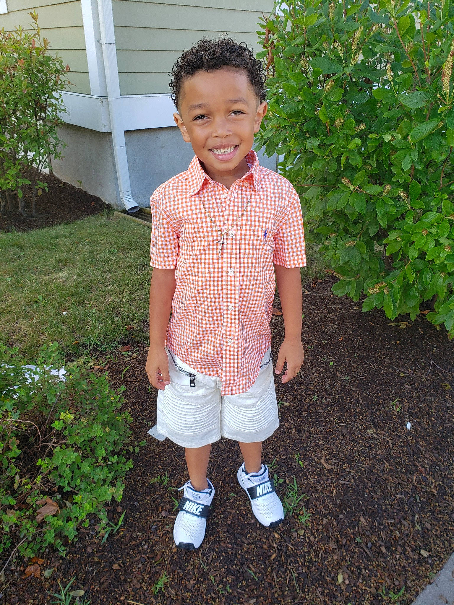 Bernard is registered to the contest to win money with this photo: backyard, child, clothing, footwear, garden, joy, pattern, person, plant, shoe, sleeve, smile, summer, t_shirt, toddler, uniform, yard