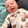 Noah joined the competition — help win amazing prizes! baby, infant, smiling, face, blanket, clothing, sleeper, pattern, construction_vehicles, happy, lying_down, black_surface, blue_blanket, cute, child, portrait, indoors, young, small, wearing