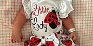 Delilah is registered to the contest to win money with this photo: baby, newborn, sleeping, infant, clothing, headband, bow, ladybug, pattern, blanket, cute, peaceful, resting, skin, hand, foot, dress, soft, portrait, child