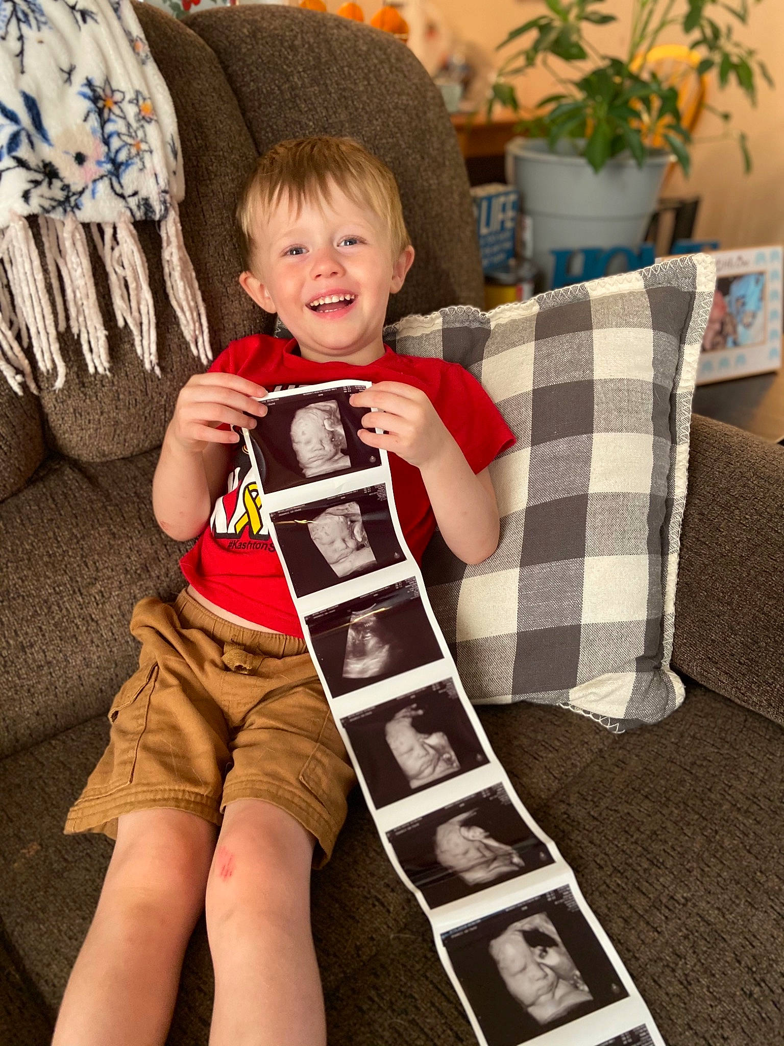 Kyson joined the competition — help win amazing prizes! baby_toddler_clothing, comfort, couch, elbow, flowerpot, happy, houseplant, human_leg, joy, knee, lap, leg, pattern, person, plant, sleeve, smile, t_shirt, textile, thigh