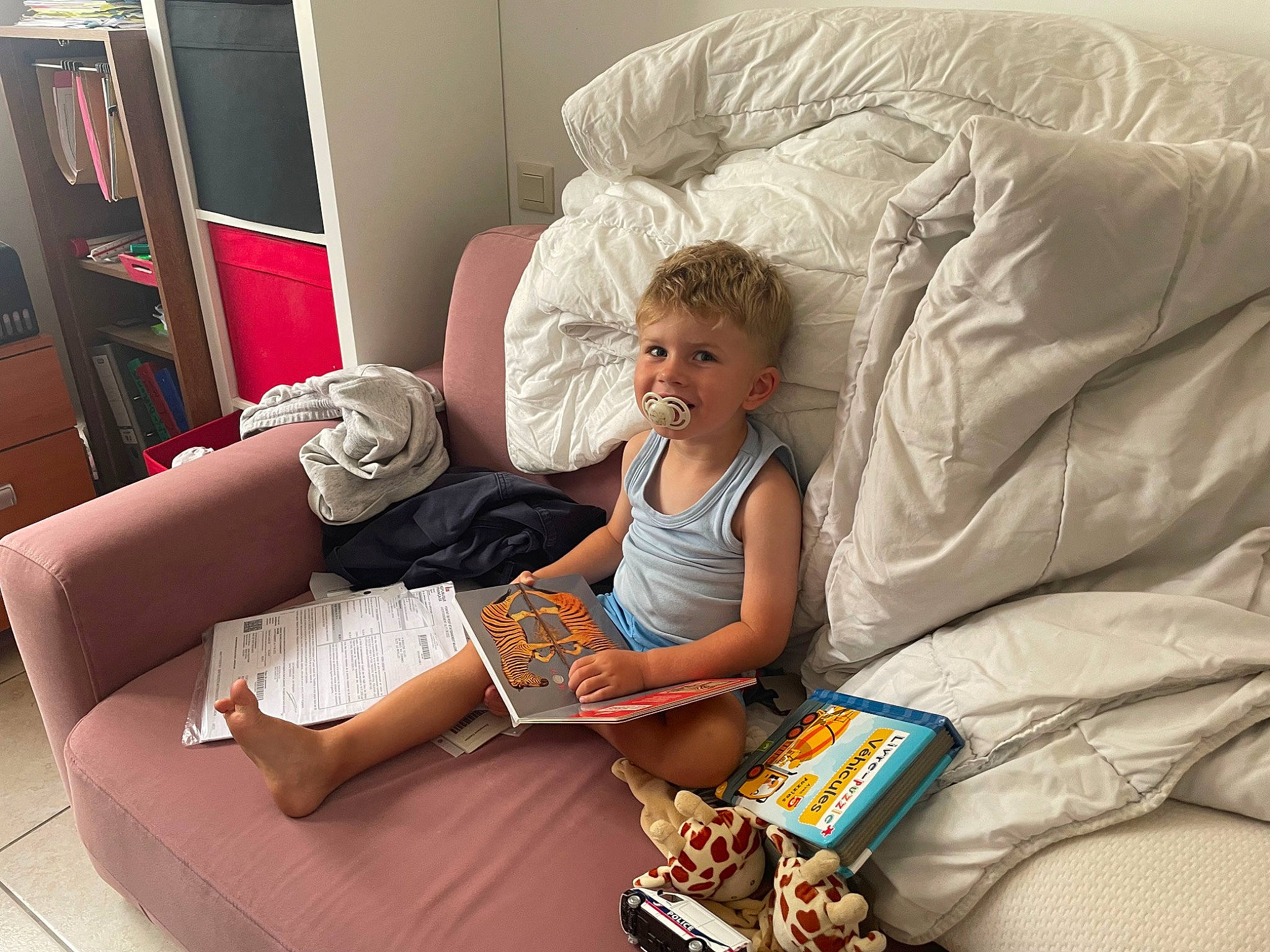 Eden participe au concours pour gagner de l'argent avec cette photo : bedding, bedroom, child, comfort, couch, flooring, food, leisure, linens, living_room, mammal, person, pillow, room, sitting, smile, studio_couch, t_shirt, textile, throw_pillow