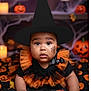 baby, child, halloween, witch_hat, costume, face_paint, pumpkin, jack_o_lantern, blanket, orange, black, bat_brooch, candle, fall_leaves, portrait, cute, holiday, celebration, indoors, toddler