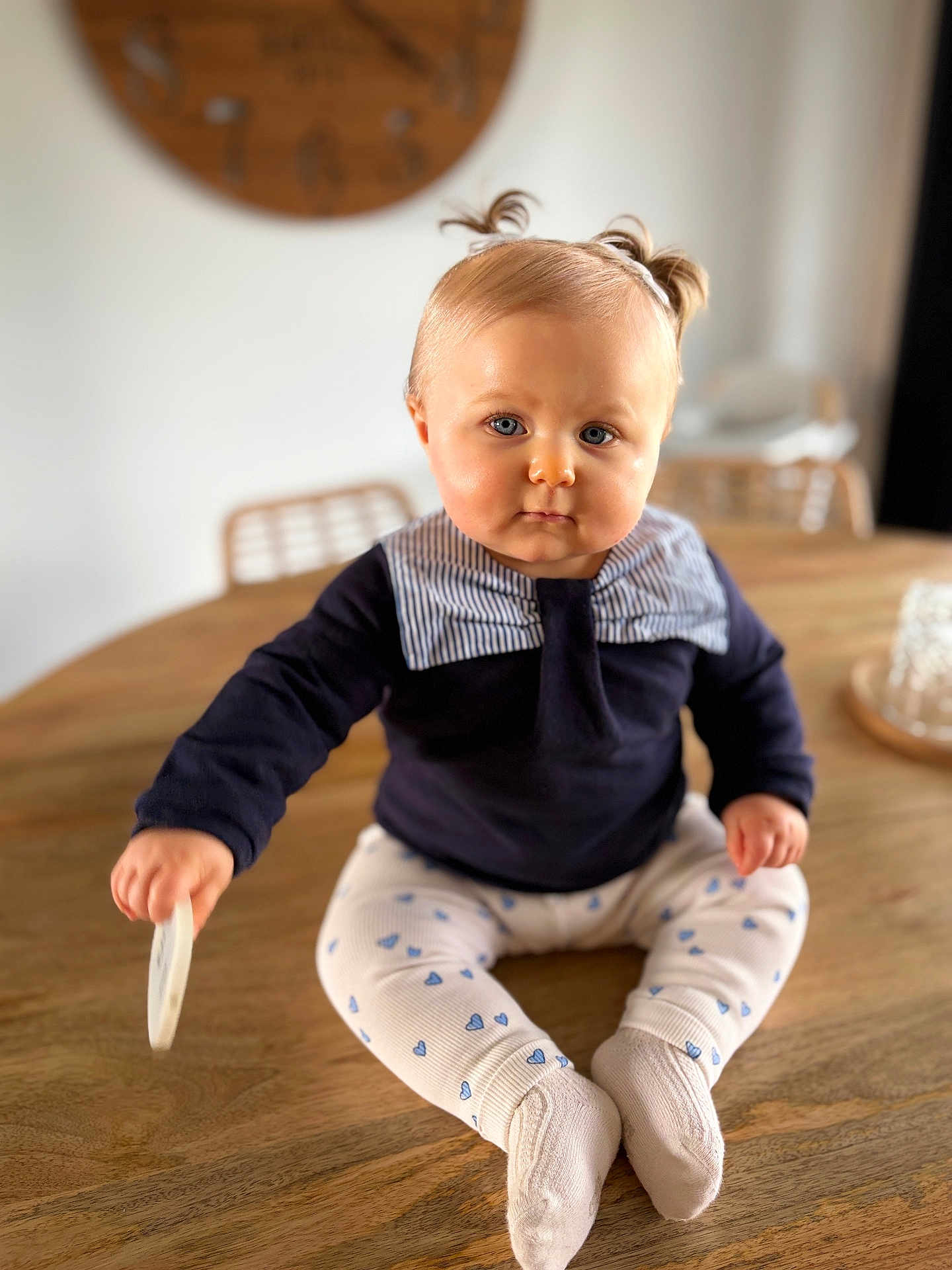 Louise participe au concours pour gagner de l'argent avec cette photo : baby, infant, child, portrait, cute, tabletop, wooden_table, pigtails, blue_eyes, navy_sweater, striped_collar, patterned_leggings, socks, toy, sitting, indoor, bokeh, chair, warm_lighting, face