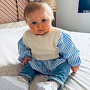 Louise a rejoint le concours — aidez-le/la à gagner de superbes lots ! baby, infant, child, toddler, portrait, blue_eyes, knitted_vest, striped_shirt, jeans, white_sneakers, bed, bedding, wicker_headboard, lamp, hair_bow, sitting, indoors, cute, rosy_cheeks, family_photo