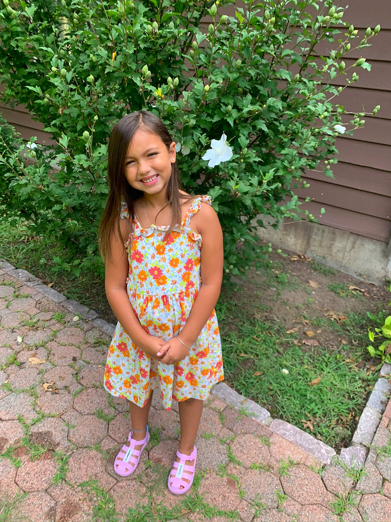 Kira is registered to the contest to win money with this photo: baby_toddler_clothing, clothing, day_dress, eye, garden, grass, groundcover, hair, happy, head, joy, magenta, pattern, people_in_nature, person, pink, plant, sandal, shrub, smile