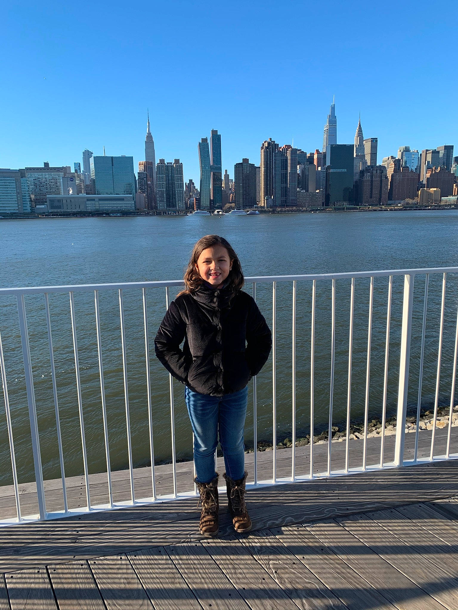 Kira is registered to the contest to win money with this photo: architecture, building, daytime, fence, footwear, infrastructure, jacket, jeans, joy, lake, leg, light, line, person, photograph, sky, skyscraper, street_fashion, sunglasses, thigh