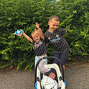 Leonardo participe au concours pour gagner de l'argent avec cette photo : baby, bushes, car_seat, child, cute, family, greenery, happy, newborn, outdoor, pavement, person, playing, plush_toy, sibling, smiling, sportswear, striped_shirt, stroller, toy