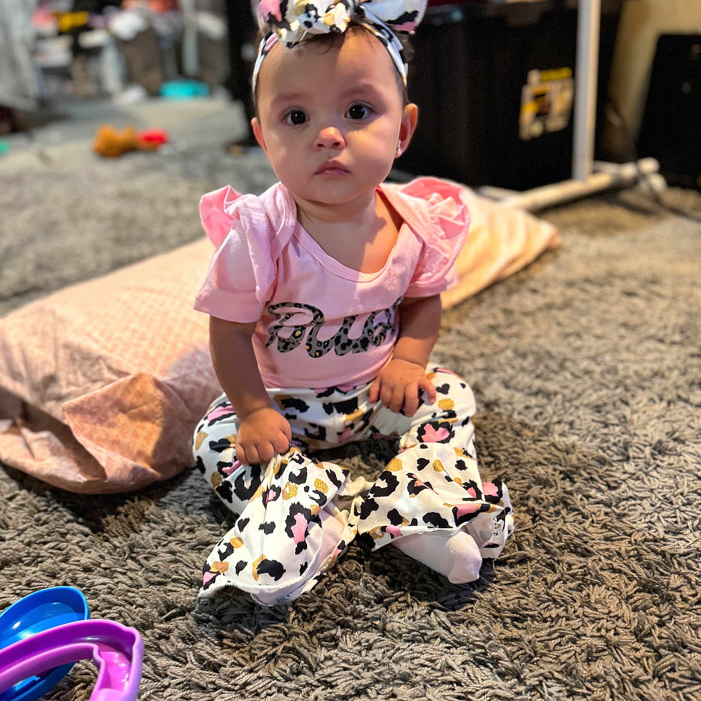 Azrahbella is registered to the contest to win money with this photo: baby, carpet, child, clothing, cute, earrings, expression, floor, footwear, headband, home, indoor, leopard_print, person, pink_clothing, play, sitting, soft_lighting, toy, young_child