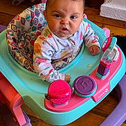 Azrahbella is registered to the contest to win money with this photo: baby, child, baby_walker, colorful, wooden_floor, indoor, onesie, patterned_clothing, face, expression, toy, pink, purple, blue, wood, flooring, infant, person, cute, scrunched_face