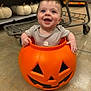 baby, child, costume, cute, decorative_pumpkins, festive, floor, halloween, happy, holiday, indoor, infant, orange, person, playful, pumpkin_bucket, seasonal, shopping_cart, smiling, store