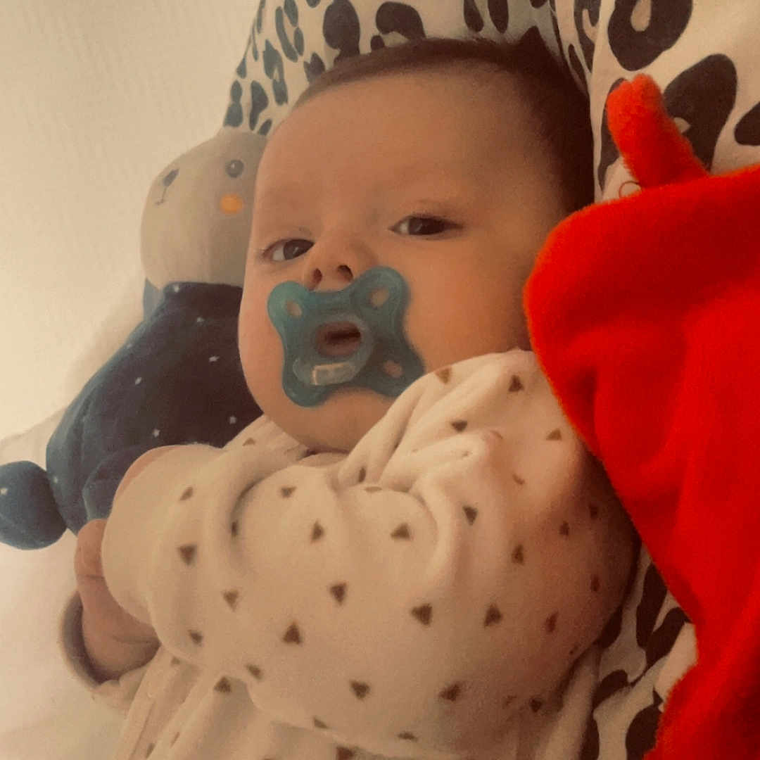 Kayzen participe au concours pour gagner de l'argent avec cette photo : baby, bedroom, blanket, child, comfort, cozy, cute, face, indoor, infant, lying_down, pacifier, patterned_fabric, pillow, plush_toy, portrait, resting, sleepwear, soft_toys, young_child