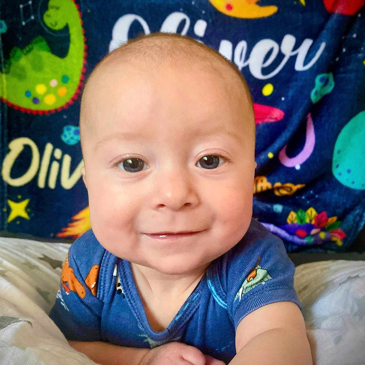 Oliver is registered to the contest to win money with this photo: baby, bed, bedroom, clothing, cushion, face, furniture, happy, head, homedecor, indoors, person, photography, portrait, quilt, room, selfie, sitting, smile, t_shirt