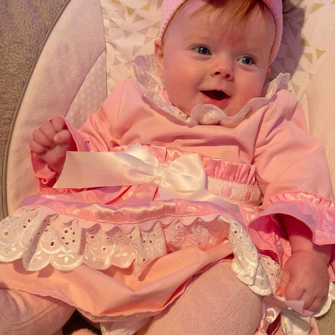 Myla-Rae joined the competition — help win amazing prizes! baby, baby_girl, bow, child, closeup, clothing, cushion, cute, happy, headband, indoors, infant, person, pink_dress, portrait, seat, smiling, soft_texture, tights, young_child