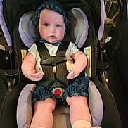 Ava is registered to the contest to win money with this photo: baby, car_seat, child, infant, clothing, bonnet, seatbelt, cute, indoor, person, portrait, legs, hands, socks, fabric, headwear, baby_girl, car_interior, seat, straps