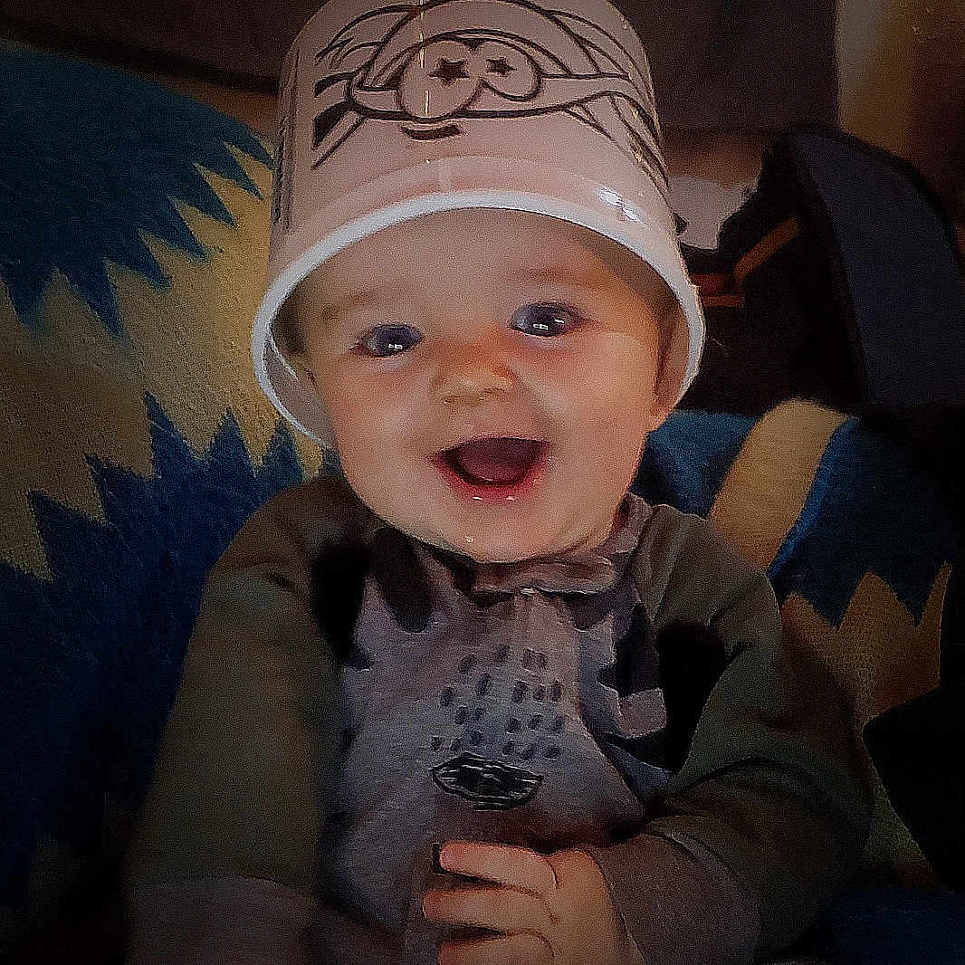 Rolland joined the competition — help win amazing prizes! baby, blanket, bucket, child, clothing, cozy, cute, face, fun, hand, happy, headwear, indoor, infant, pattern, playful, portrait, sitting, smiling, young