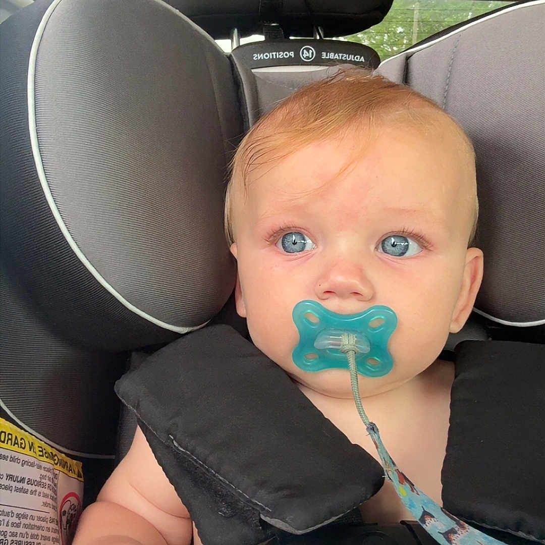 Daxson joined the competition — help win amazing prizes! baby, infant, child, car_seat, pacifier, blanket, portrait, face, blue_eyes, red_hair, sitting, secured, vehicle, car_interior, headrest, safety_harness, cozy, close_up, indoors, photography