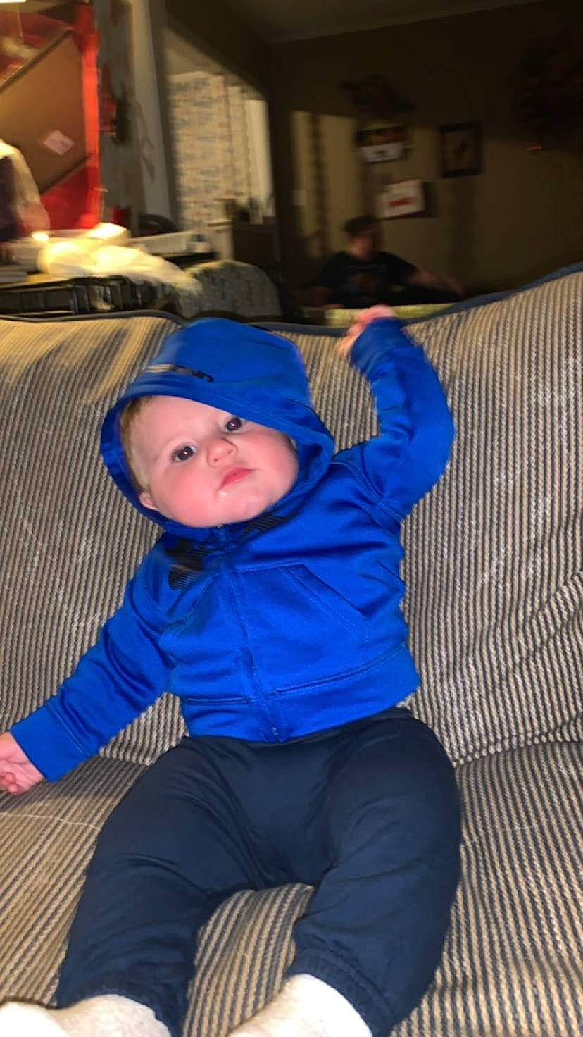 Karson is registered to the contest to win money with this photo: baby, baby_toddler_clothing, cheek, child, comfort, couch, electric_blue, flash_photography, fun, hat, headgear, hoodie, lap, person, purple, room, sitting, toddler, tree, under_exposed