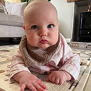 Novie is registered to the contest to win money with this photo: baby, infant, child, face, hands, pajamas, bib, play_mat, indoor, floor, curious, drool, cute, chubby_cheeks, person, portrait, home, soft_lighting, close_up, expression