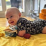 baby, infant, smiling, lying_down, blanket, indoors, happy, fabric, clothing, floor, head, face, cheerful, toddler, home, cushion, soft_toy, natural_light, portrait, cute