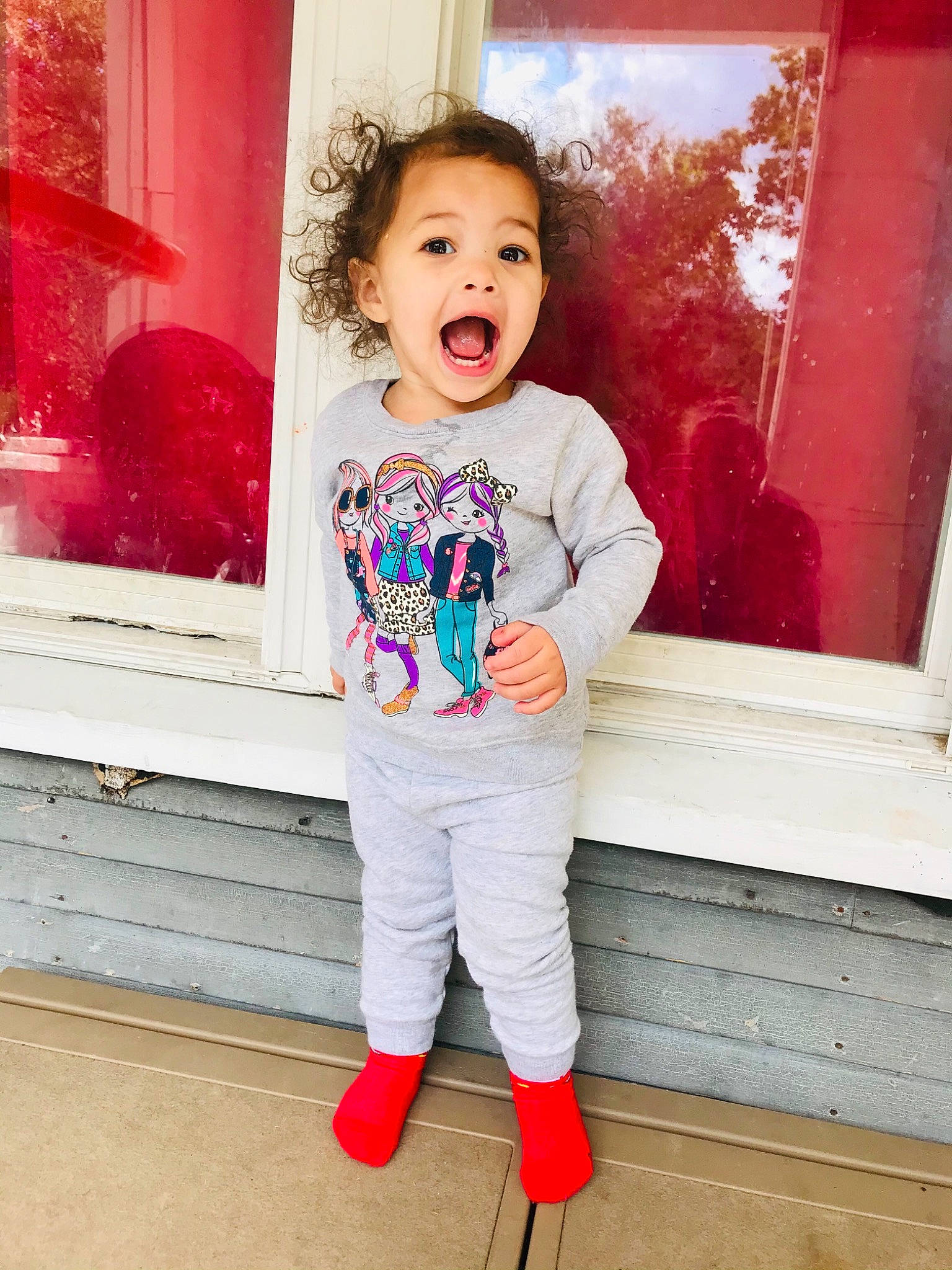 Sia is registered to the contest to win money with this photo: child, child_model, clothing, footwear, happy, jeans, outerwear, person, pink, red, shoe, sleeve, sportswear, standing, surprise, t_shirt, toddler, trousers