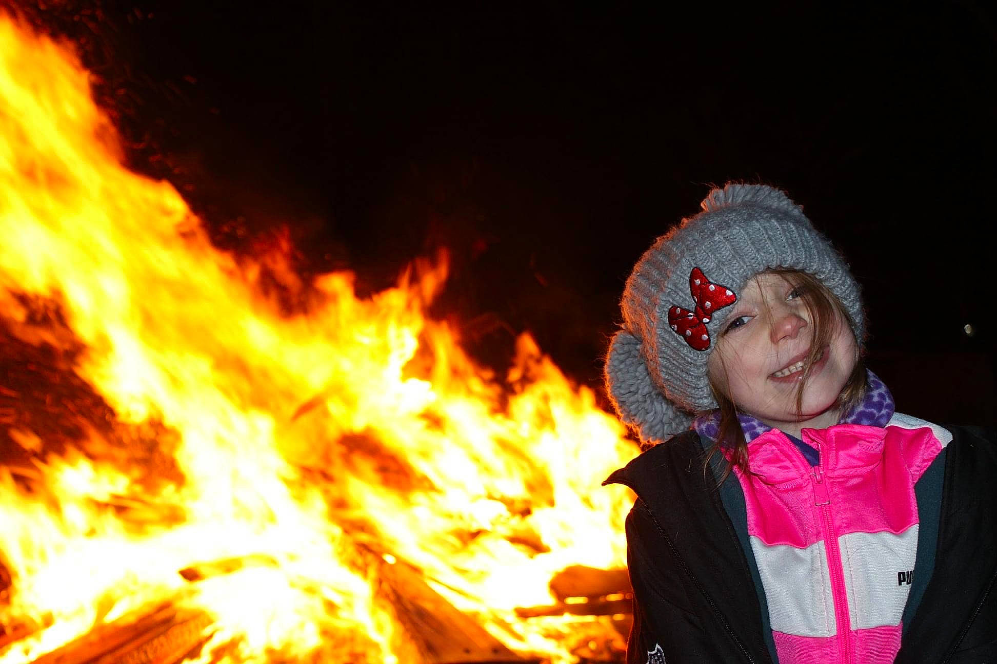 Evelyn is registered to the contest to win money with this photo: bonfire, campfire, event, fire, flame, flash_photography, fun, gas, happy, headwear, heat, hood, hoodie, joy, night, people, person, pollution, scarf, smile