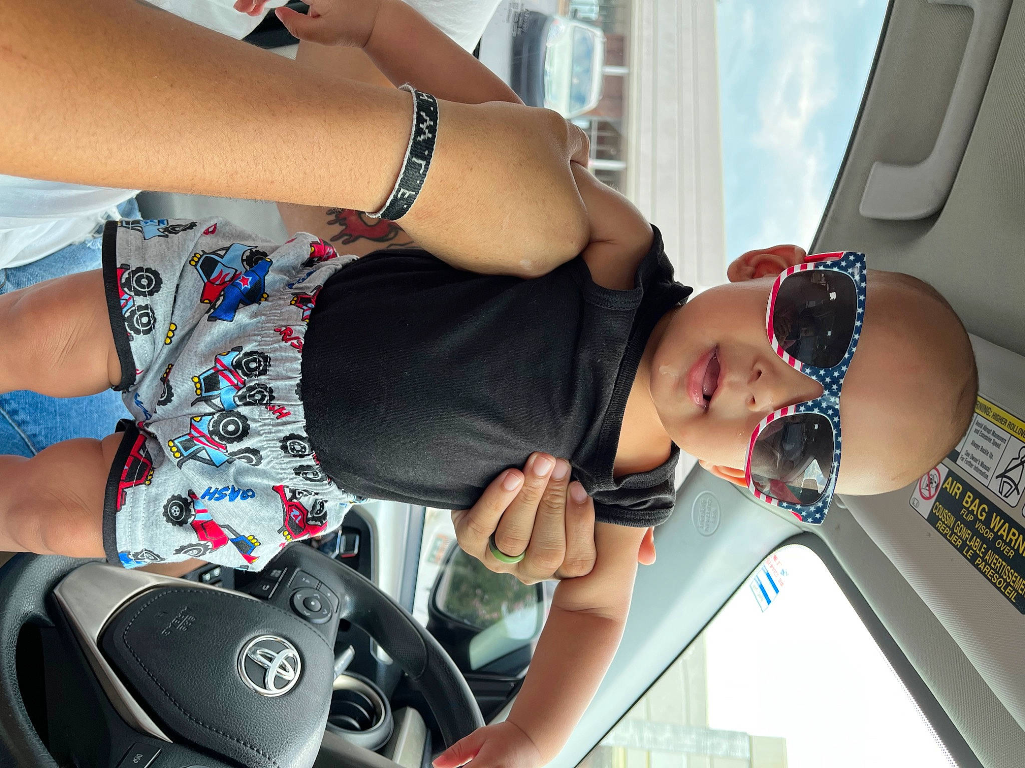 River is registered to the contest to win money with this photo: arm, automotive_design, black_hair, cool, elbow, eyewear, finger, gesture, glasses, hand, human_body, joint, leg, motor_vehicle, muscle, person, shoulder, sunglasses, thigh, vision_care