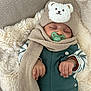 baby, sleeping, pacifier, hat, scarf, blanket, cozy, cute, infant, clothing, warm, resting, child, soft, fuzzy, hands, striped_sleeves, green, beige, portrait