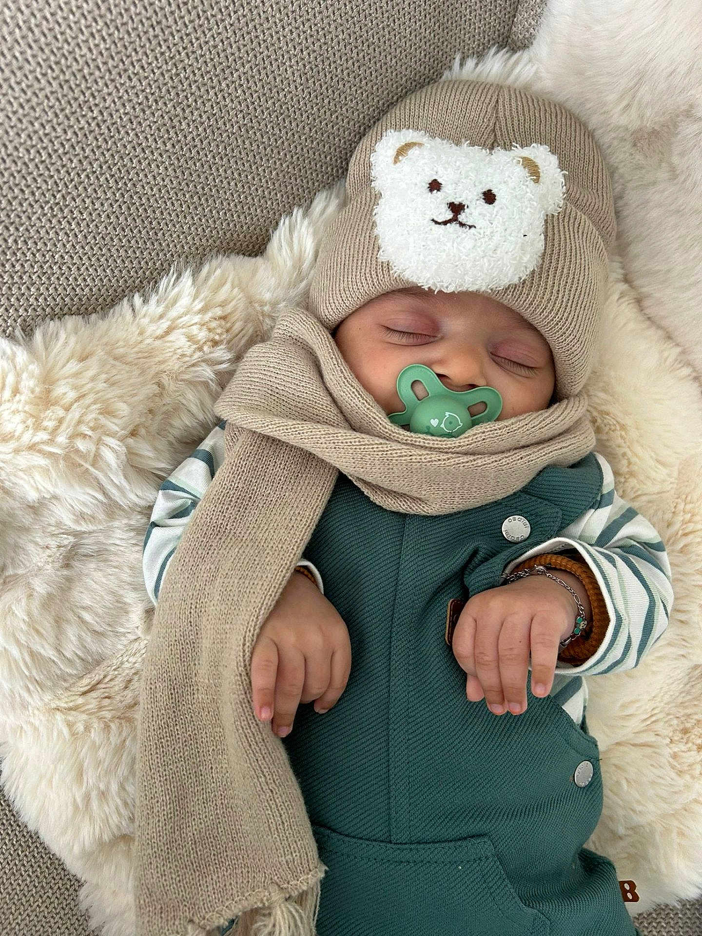 Naoufel a rejoint le concours — aidez-le/la à gagner de superbes lots ! baby, sleeping, pacifier, hat, scarf, blanket, cozy, cute, infant, clothing, warm, resting, child, soft, fuzzy, hands, striped_sleeves, green, beige, portrait
