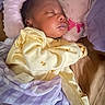 Divinity is registered to the contest to win money with this photo: baby, sleeping, infant, yellow_onesie, blanket, pillow, pink, purple, bed, resting, cute, cozy, child, soft, peaceful, indoors, face, person, newborn, sleep