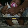 Divinity is registered to the contest to win money with this photo: baby, pacifier, arm, hand, blanket, person, infant, clothing, sleepy, comfort, cuddle, cute, indoors, rest, toddler, holding, text_overlay, emoji, dark_background, soft_lighting