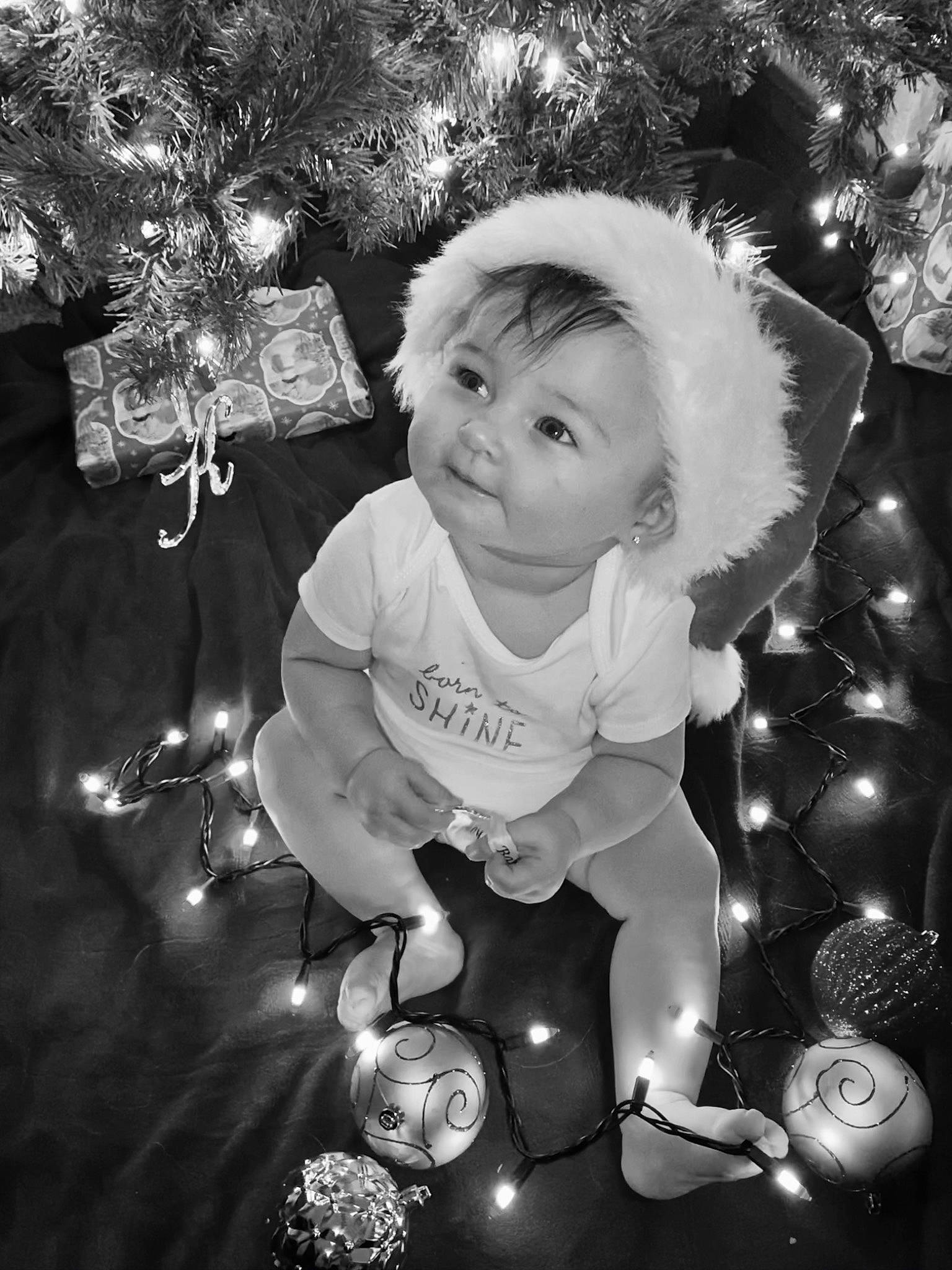 Khloe is registered to the contest to win money with this photo: baby, black, black_and_white, christmas_decoration, christmas_ornament, christmas_tree, event, eye, flash_photography, happy, human_body, monochrome, monochrome_photography, ornament, person, photograph, standing, style, toddler, tree