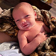 Tamen joined the competition — help win amazing prizes! baby, newborn, blanket, smile, eyes, hand, skin, face, head, couch, cozy, plush, portrait, indoors, bed, resting, closeup, soft_lighting, infant, human