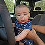 Kingston is registered to the contest to win money with this photo: baby, child, infant, car_interior, steering_wheel, hand, blue_clothing, nautical_pattern, seat, window, sunlight, person, cute, curious, holding, arm, head, eyes, expression, vehicle