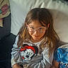 Sophia a rejoint le concours — aidez-le/la à gagner de superbes lots ! casual, child, clothing, comfortable, couch, family, girl, glasses, heart_emoji, indoors, long_hair, minnie_mouse, person, phone, pillow, playful, seated, smiling, sweatshirt, text_overlay