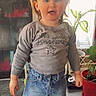 Sophia a rejoint le concours — aidez-le/la à gagner de superbes lots ! bow, casual, child, clothing, denim_skirt, face, floor, footwear, girl, hairband, head, home, indoor, plant, potted_plant, smiling, socks, standing, sweater, toddler