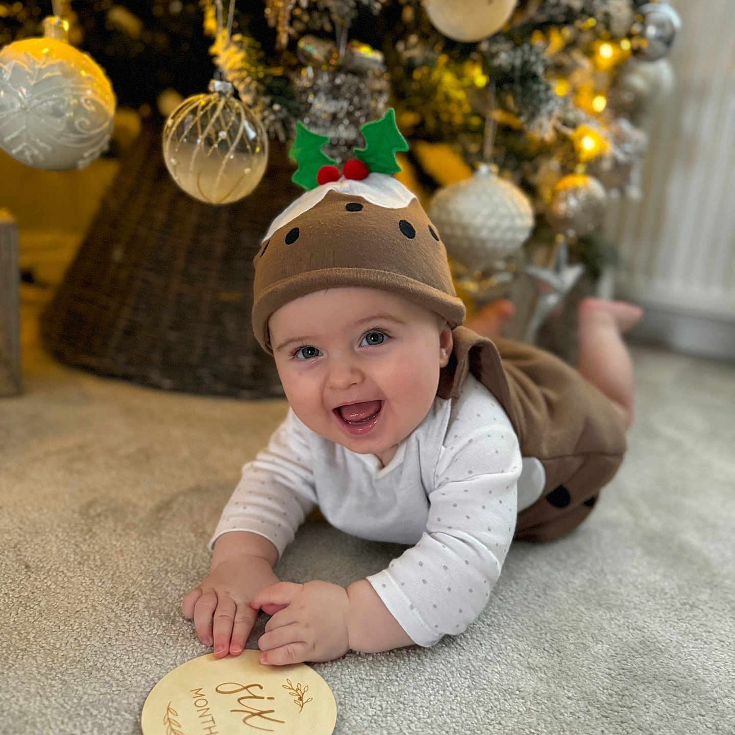 Oakley is registered to the contest to win money with this photo: accessories, baby, cap, christmas, christmasdecorations, christmastree, clothing, face, festival, happy, hat, head, laughing, lighting, person, photography, plant, portrait, smile, tree
