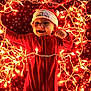 baby, blanket, celebration, cheerful, child, christmas, cozy, cute, festive, glowing_lights, holiday, indoors, infant, lights, lying_down, portrait, red_onesie, santa_hat, smiling, snowflake_pattern