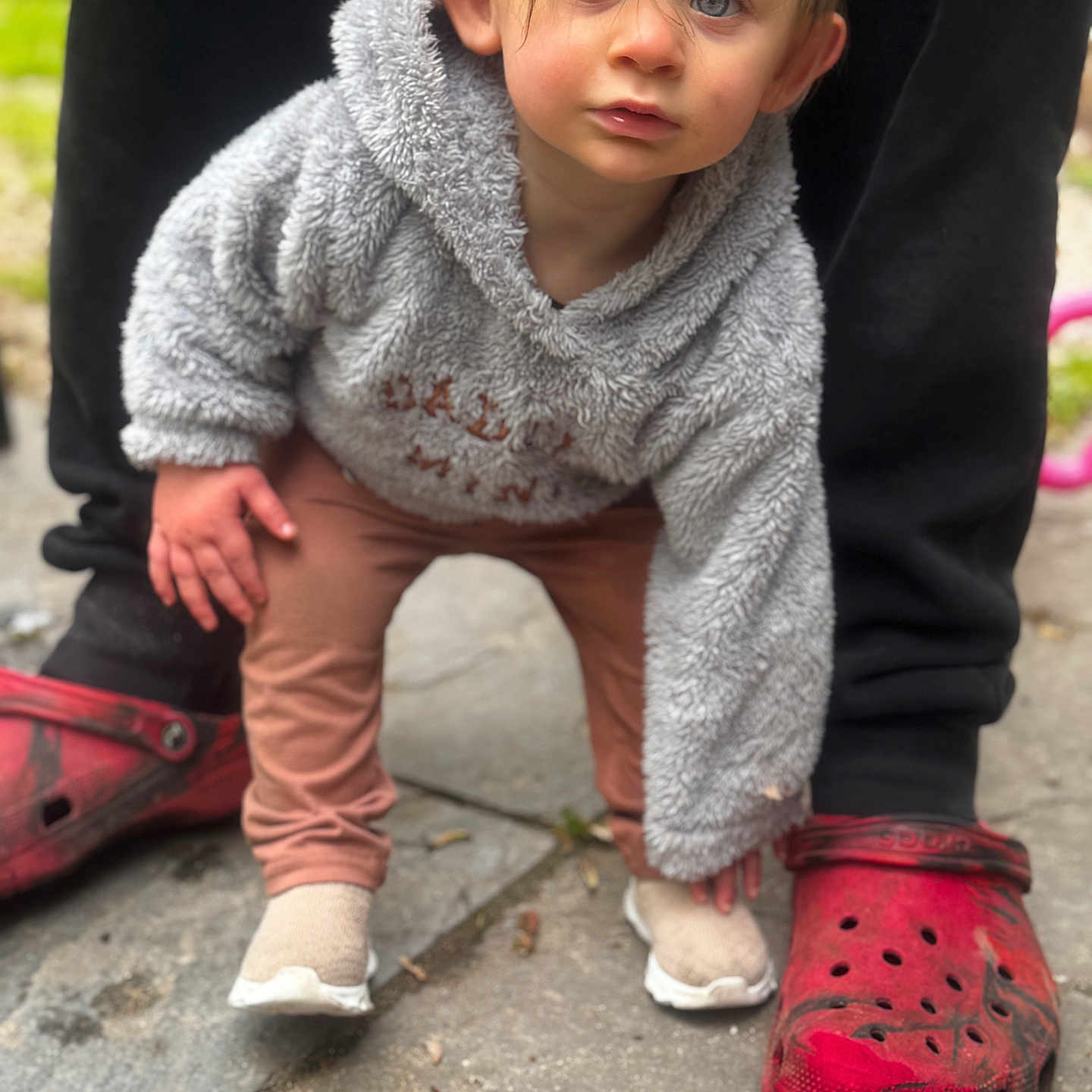 Bria joined the competition — help win amazing prizes! toddler, child, hoodie, gray_clothing, crawling, outdoor, sidewalk, red_crocs, adult_legs, curious, blue_eyes, casual_shoes, person, pants, footwear, young_child, expression, clothing, portrait, closeup